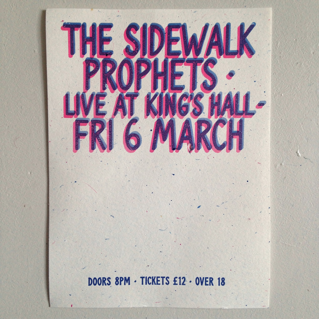 Risograph-printed gig poster on coarse newsprint, two-color overlap (electric pink + cobalt blue), visible registration misalignment. Hand-drawn condensed sans title reads exactly: "THE SIDEWALK PROPHETS · LIVE AT KING\'S HALL · FRI 6 MARCH". Below in smaller mono type: "DOORS 8PM · TICKETS £12 · OVER 18". Grain, halftone dots, slight ink spread at edges. Single occurrence of each text block, no duplication.